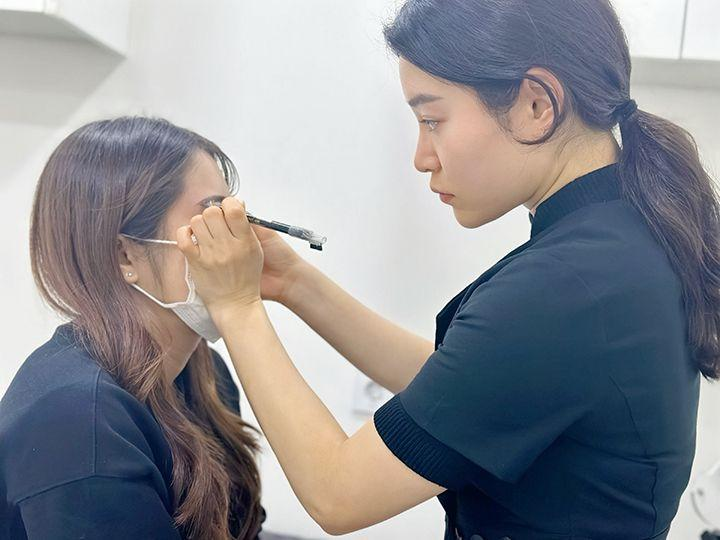 Kỹ thuật viên tư vấn và tạo dáng chân mày cho khách